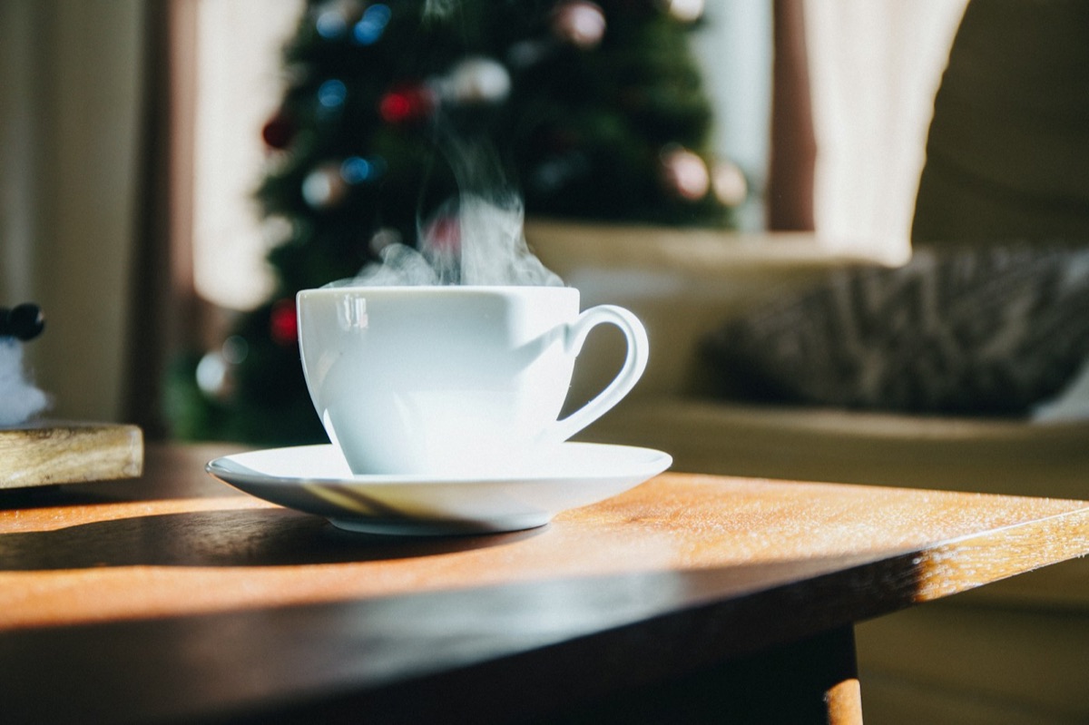 A steaming cup of tea in a warm, cosy living room