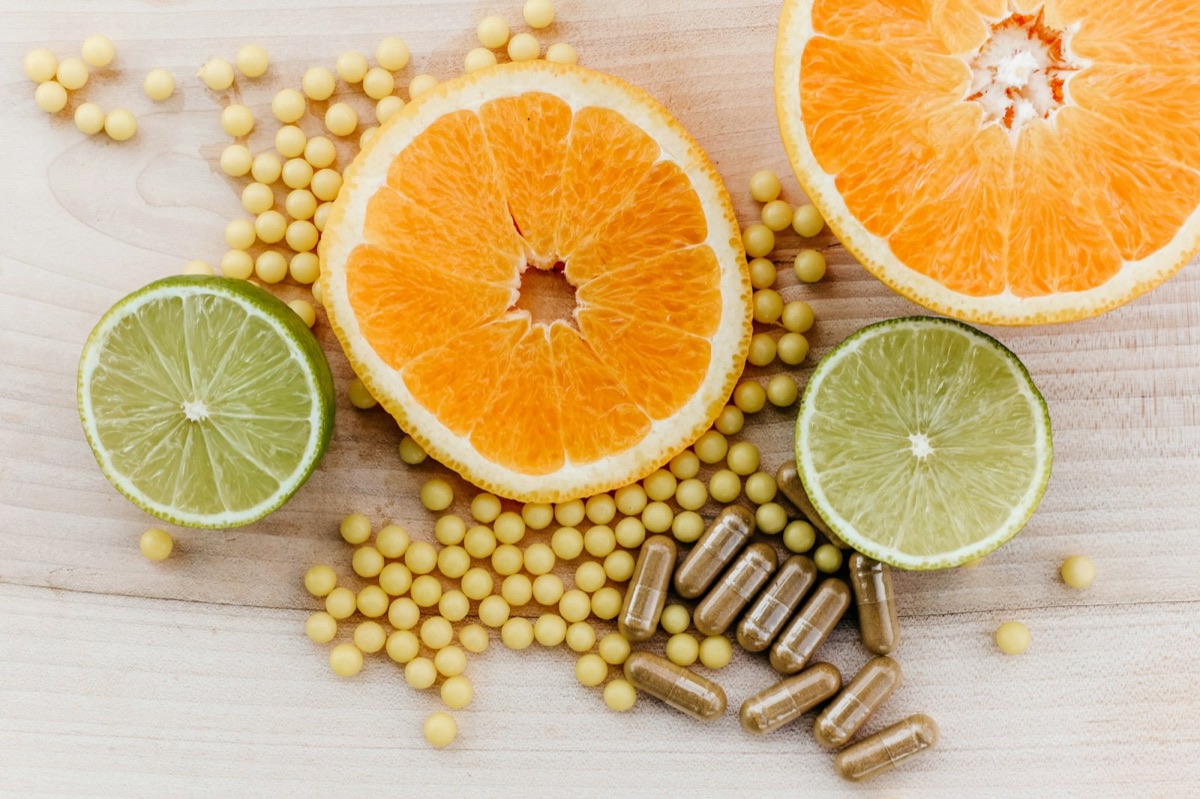 Citrus slices and supplement capsules on a wooden table